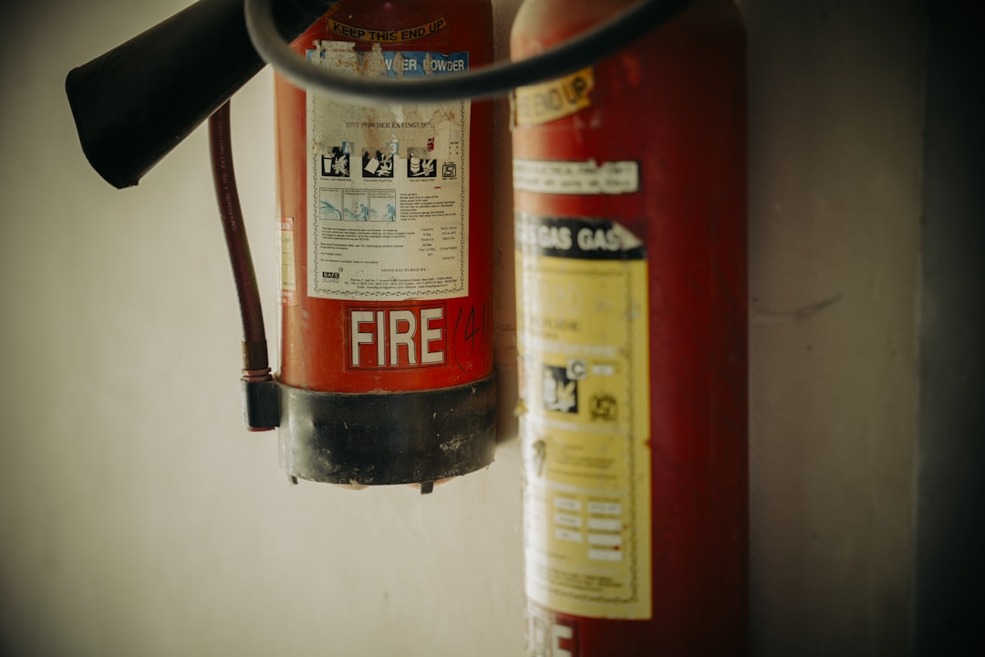 Two red fire extinguishers hung on wall.