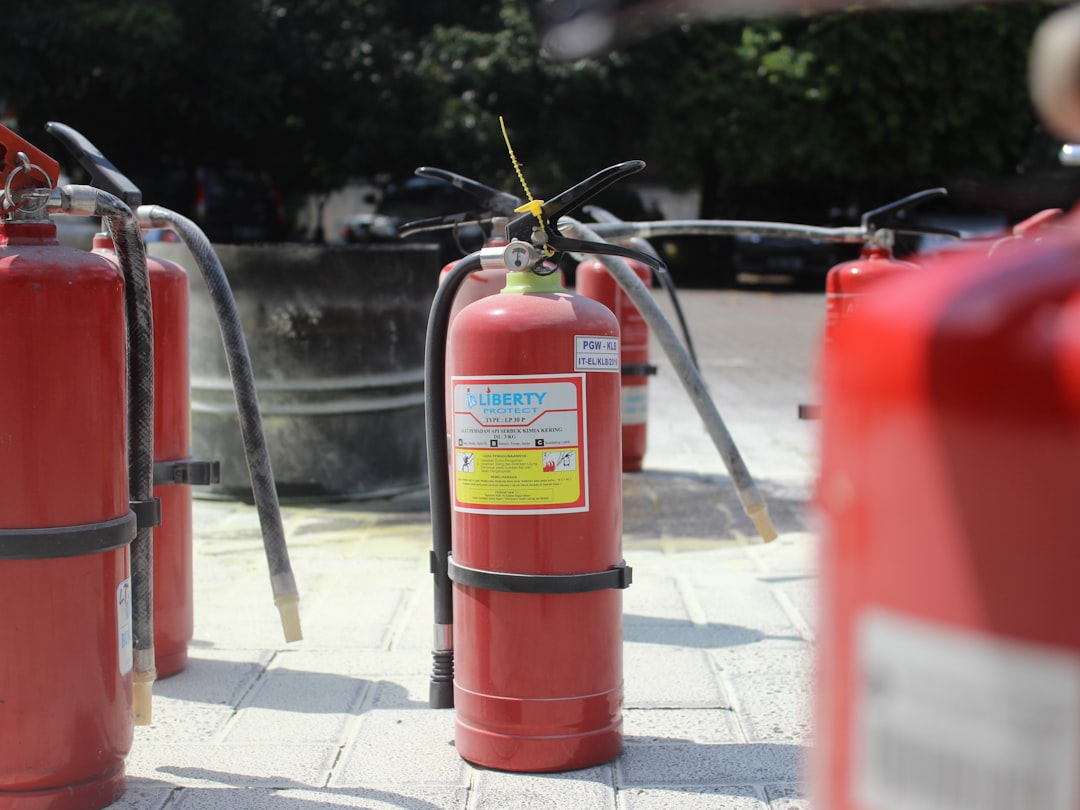 a group of red fire extinguishers sitting on a sidewalk