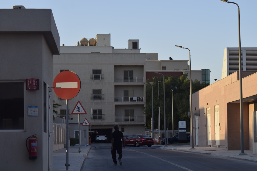 Man walks down street with buildings and signs