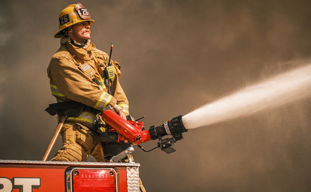 Firefighter uses a hose to put out a fire.